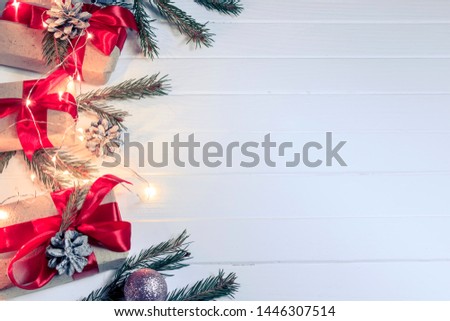 Christmas background concept. Top view of Christmas gift box with spruce branches, pine cones, red berries on white wooden table background.