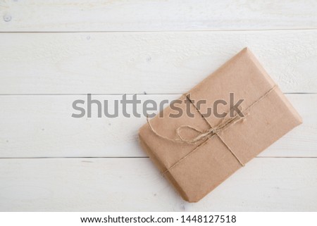 parcel,gift Packed in eco-friendly paper on light wooden background. the view from the top