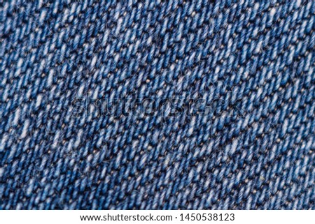 Macro texture of blue denim. Close-up with selective focus. Original background. Interesting pattern  
