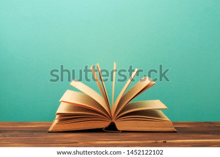 Open book on wooden vintage table blue background - Image 