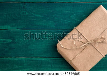 parcel,gift Packed in eco-friendly paper on dark green wooden background. the view from the top