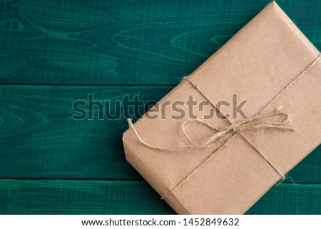 parcel,gift Packed in eco-friendly paper on dark green wooden background. the view from the top