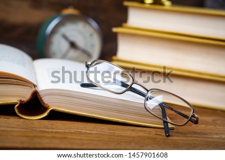 Open tutorial with glasses on the table in the audience. Education concept - books on the desk in the auditorium. On a wooden background. selective focus