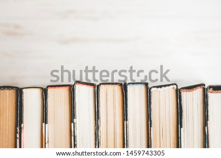 Stack of old books, textbooks on a white wooden background. Books in a row on a light background