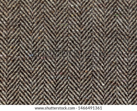 Brown woolen fabric striped zigzag. Herringbone tweed, Wool Background Texture. Coat close-up. Expensive men's suit fabric. High resolution