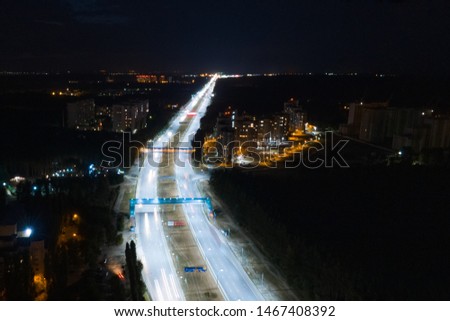 Hyperlapse timelapse of night city traffic fast cars driving around on the highway. Aerial view