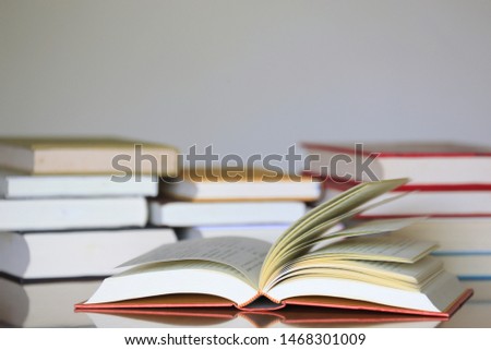 Open book on the table in the library Many books are stacked in the background selective focus and shallow depth of field