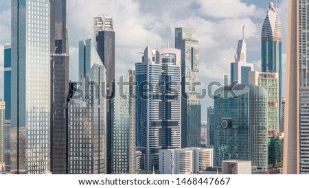 Aerial view on downtown and financial district in Dubai timelapse, United Arab Emirates with skyscrapers and highways. Cloudy sky