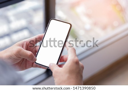 Mockup image screen cell phone.men hand holding texting using mobile at office.display with white blank space for advertise text.concept for contact business,people communication,technology device