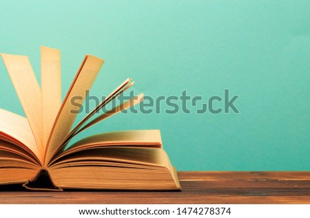 Open book on wooden vintage table blue background - Image 