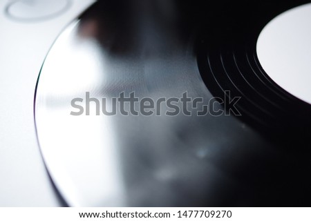 Grooves of tracks on vinyl record disc with white label on turntable
