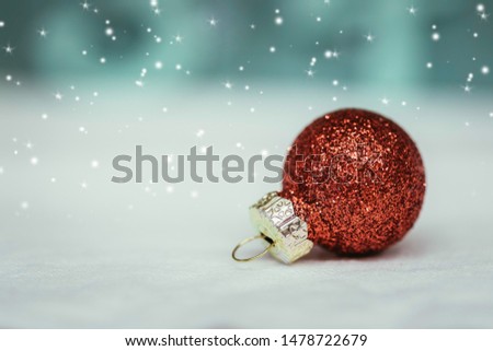 Christmas decoration: Close up of red Christmas bauble, lights in the blurry background