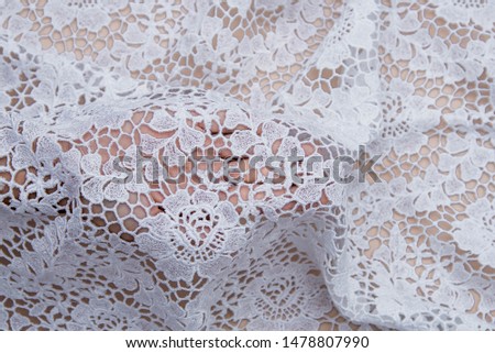  White lace on beige background.