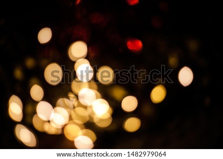 Bright large yellow and red blurry bokeh lights on a black background.