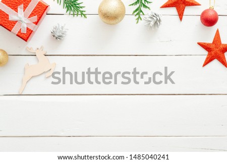Christmas composition. Christmas frame border made of red gift box, stars, ornaments on wooden white background. Greeting card template, winter holiday banner mockup. Flat lay, top view, overhead.