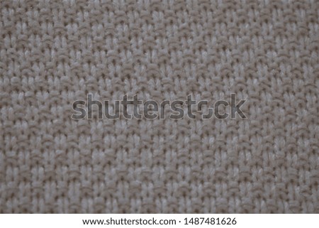 wool sweater texture close up. Abstract knitted background texture in light tone, knitted by hand.