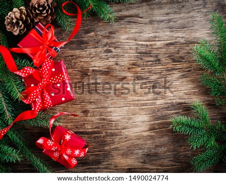 Christmas background concept. Christmas gift box with spruce branches, pine cones on wooden background, copy space