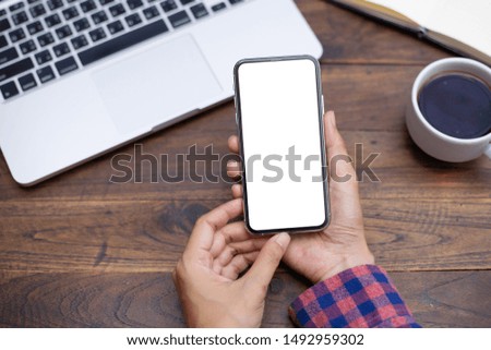 Mockup image blank white screen cell phone.woman hand holding texting using mobile on desk at coffee shop. background empty space for advertise text. contact business,people communication,technology