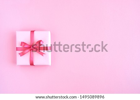 Gift box with ribbon and bow on color background and space for text. Top view                     