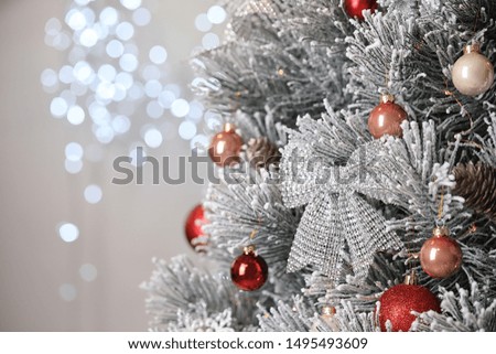 Beautiful Christmas tree with festive decor against blurred lights on background. Space for text