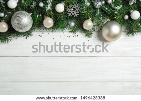 Fir tree branches with Christmas decoration on white wooden background, flat lay. Space for text
