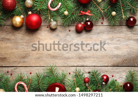 Fir tree branches with Christmas decoration on wooden background, flat lay. Space for text