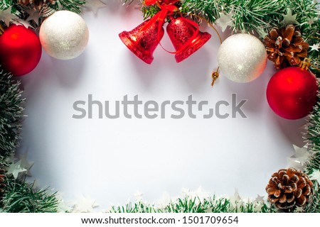 Christmas background with place for text. Fir cones in green tinsel, bells, toys.