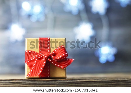Christmas gift with red ribbon on wooden background with copy space. Christmas and New Year concept	