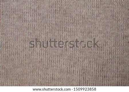 Autumn background from brown knitted wool close-up