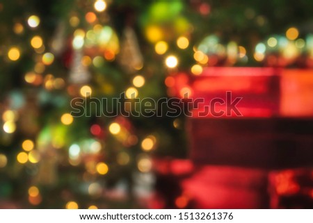 Colorful Xmas backdrop with Christmas red presents and Christmas tree lights. Defocused Christmas background. Blur Christmas traditions concept.