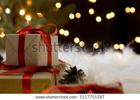 Christmas gifts and pine cones with bokeh light background.