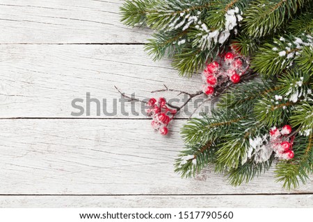Christmas greeting card with fir tree branch over old wooden texture background. Xmas backdrop. Top view with copy space for your greetings