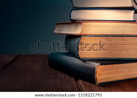 A stack of old books against a dark background with copy space, selective focus
