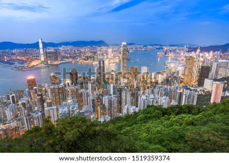 Night aerial view of light up of Hong Kong, China modern skyline of skyscrapers with blue sky.