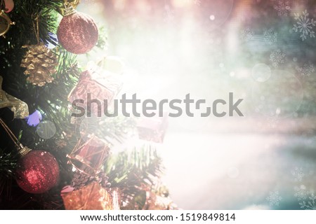 Close up Christmas decoration hanging on Christmas tree, blurred snowfall and snowflakes on snow background with copy space. Christmas background