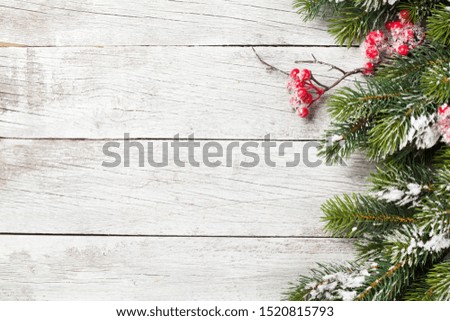 Christmas greeting card with fir tree branch over wooden background. Xmas backdrop. Top view with copy space for your greetings