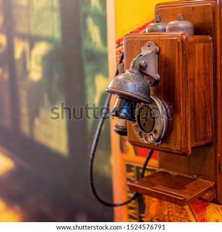 Antique vintage telephone on room background, sideview