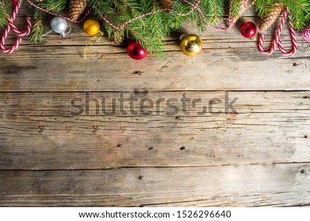 Christmas greeting background with Christmas tree branches, traditional decorations, gifts and xmas balls. Classic wooden background, top view flat lay copy space