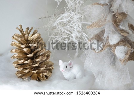 A Christmas story handcrafted. Golden cone, mouse and stylized trees