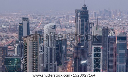 Dubai Downtown skyline futuristic cityscape with many skyscrapers and business bay aerial night to day transition timelapse. Morning panorama with modern towers and construction from rooftop before