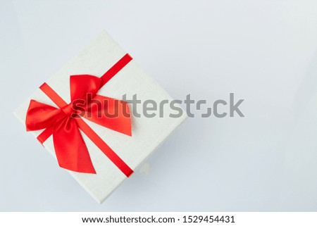 White gift box with red ribbon bow on white background, big sale, The minimal concept of giving different festive gifts, copy space for text