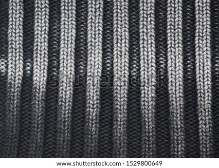 Close up of gradient ombre grey knitted striped washed out sweater. Cozy christmas monochrome macro background in vintage 90s style. Winter layers texture of soft knitwear for cold weather