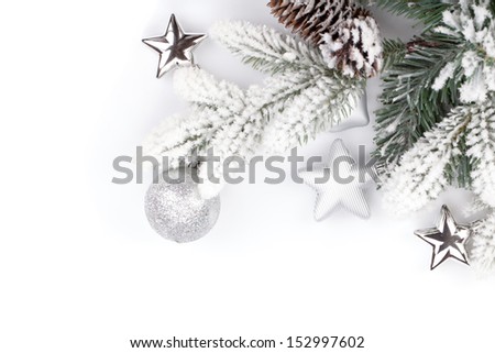 Fir tree branch with christmas decor covered with snow. Isolated on white background
