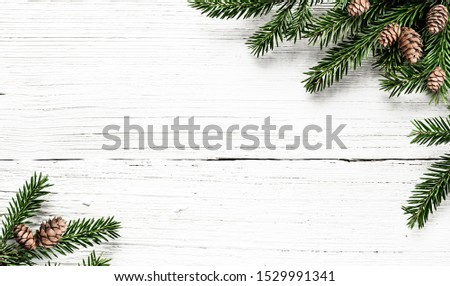 Fir tree branches and pine cones on white wood rustic background. Christmas composition.