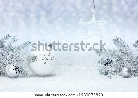fir tree branches and christmas decorations against white fluffy snow background