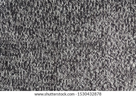 Cropped close up shot of seamless woolen knitting pattern of fall / winter season warm sweater, clearly visible fiber texture of stylish hipster knitwear clothing. Background, copy space, top view.