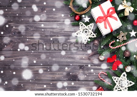 Christmas tree branches with toys and gift box on wooden table