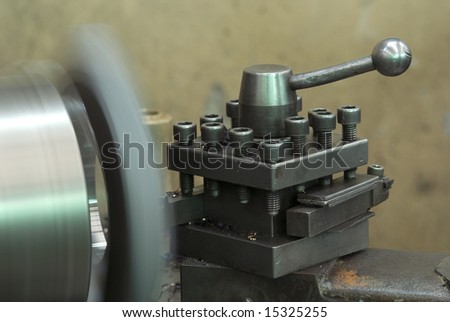 Steel lathe in production. Shallow depth of field with the control handle in focus.