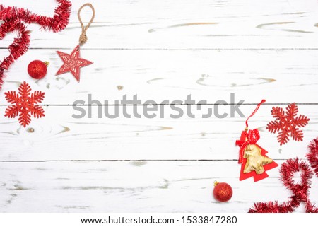 Red christmas decoration with christmas balls, star, christmas tree, garland and snowflakes on a wood background