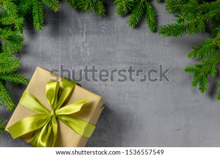 Christmas or New Year background with fir tree, pine branches, present on grey table. Happy new year concept. Gift. Copy space